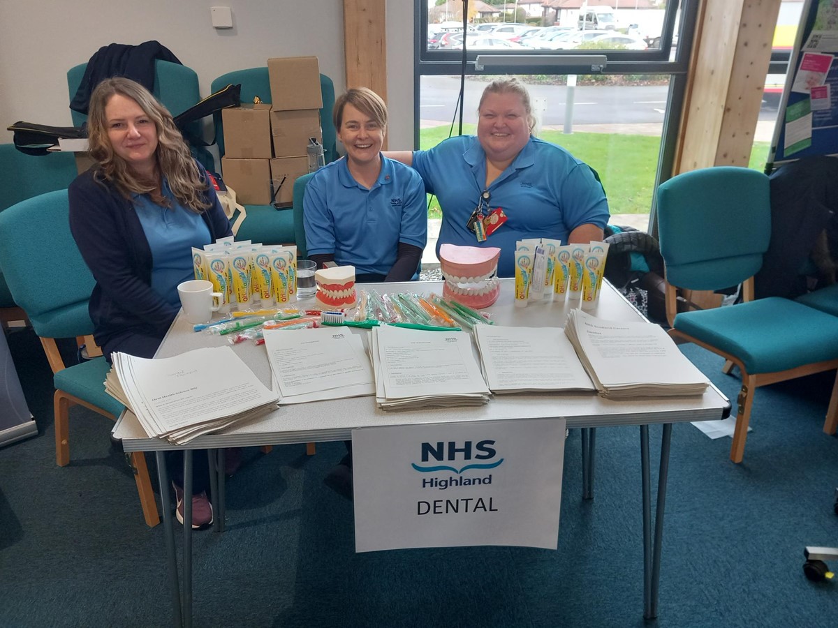 3 NHS Highland dental staff at a display table