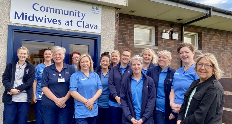 The NHS Highland Community Midwife team outside of the Clava building under a sign that says "Community Midwives at Clava"