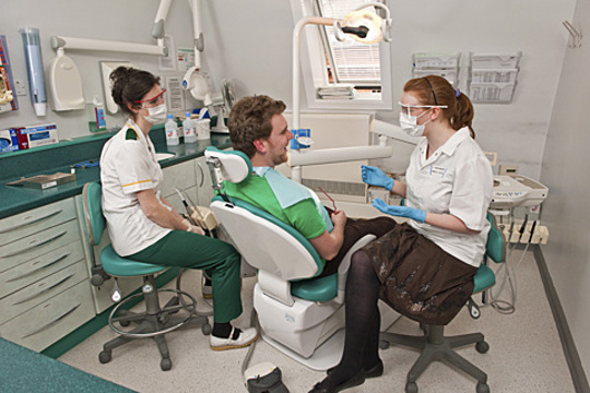 Dental Surgery With Patient Dentist And Assistant
