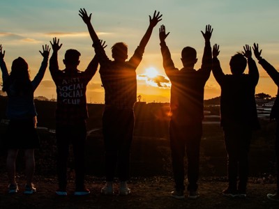 7 Children Raising Their Hands To Sunset