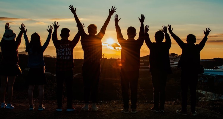 7 Children Raising Their Hands To Sunset
