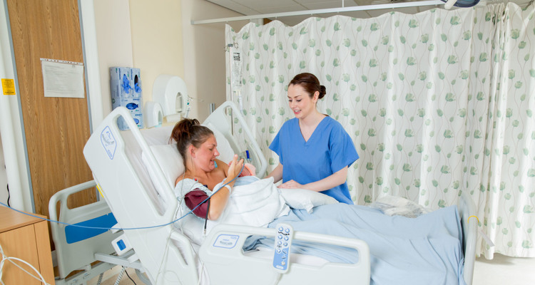 a woman and her newborn baby in a hospital post delivery suite