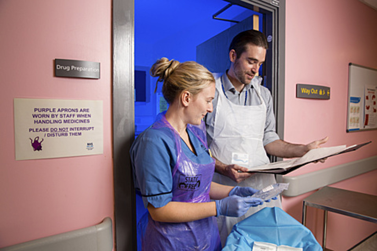 Nurse And Doctor Discussing Paper Records