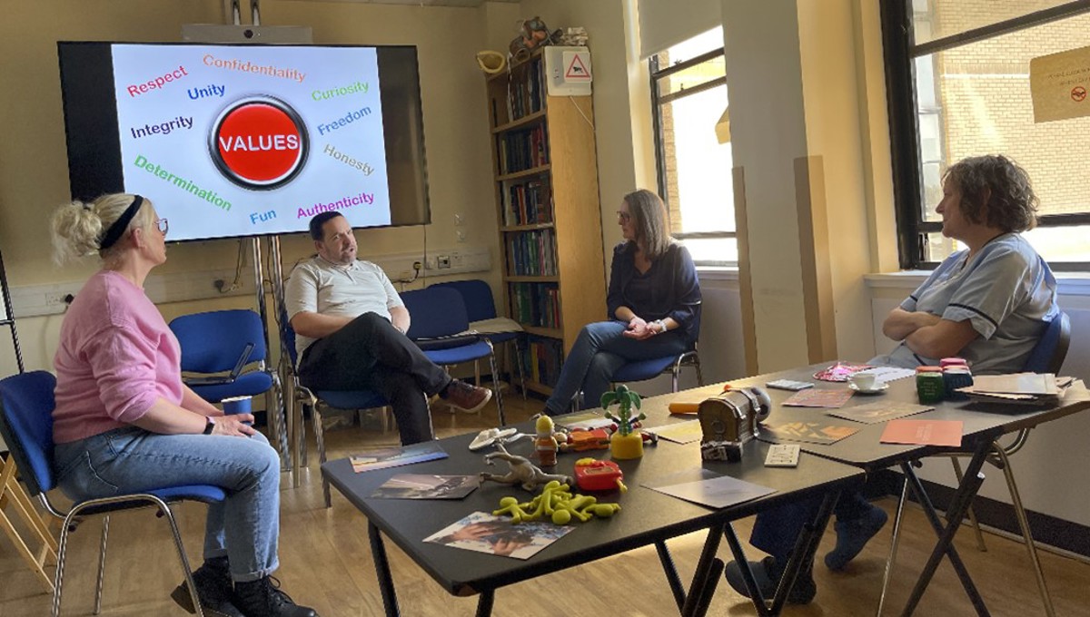 Four Staff Members In A Facilitated Group Reflections Session